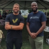Culinary Arts alumnus Daniel Lee standing with John Kirby from Dornsife Center for Neighborhood Partnership and their monthly dinner.